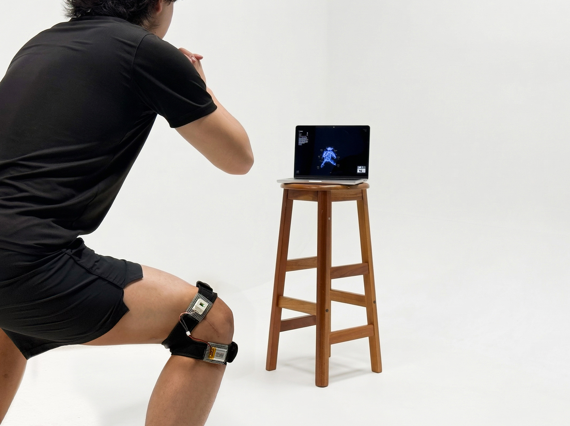 Laptop running Residual Motion on a stool, user beside it